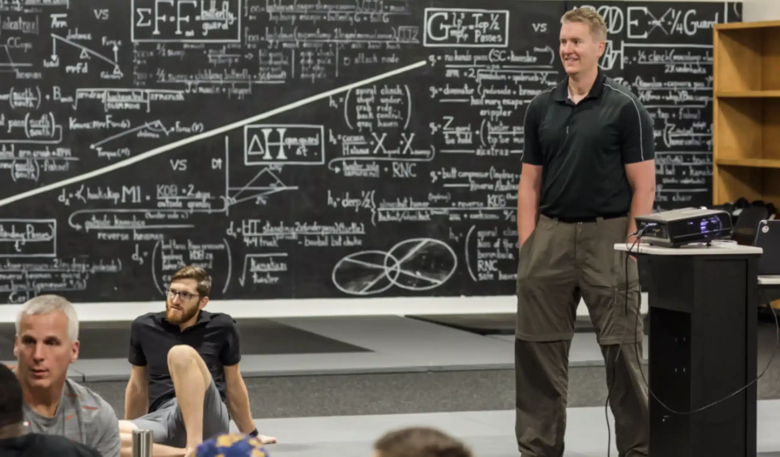 Interactive Seminar Instructor and Participants in Front of a Scientific Chalkboard Interactive Seminar Instructor and Participants in Front of a Scientific Chalkboard