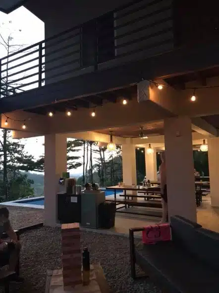 Outdoor Patio with String Lights and Poolside Seating at Dusk